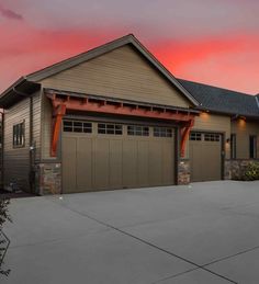 a large house with two garages and a red sky in the backround