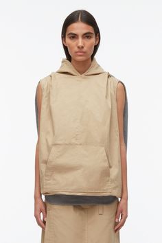 Hooded Cotton Top With Side Pockets, Cotton Vest With Side Pockets For Streetwear, Urban Cotton Vest With Side Pockets, Oversized Cotton Hoodie With Detachable Hood, Cotton Tops With Adjustable Hood For Everyday, Hooded Top With Pockets For Everyday, Cotton Tops With Kangaroo Pocket, Spring Cotton Hoodie With Detachable Hood, Relaxed Fit Cotton Top With Kangaroo Pocket