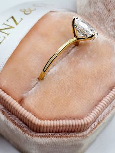 a diamond ring sitting on top of a cushion