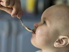 a baby is being fed with a spoon