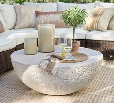 a table with two wine glasses and a candle on it in front of a couch