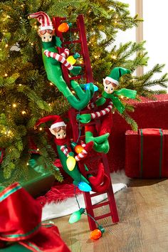 elfs climbing the ladder to decorate their christmas tree