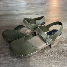 Sandgrens Victoria Classic Clog Sandal In Olive Nubuck Leather And Dark Wood Base Small Heel (~2.5") With Rubber Bottoms. Metal Buckle, In Great Used Condition. Super Comfortable And Cute, I Just Don't Wear Them Enough! Size 39 Eu. I'm Between 8 And 8.5 And They Fit Perfectly! Green Sandals With Heel Loop And Round Toe, Summer Suede Closed Toe Clogs, Suede Open Heel Clogs For Spring, Green Suede Sandals With Leather Footbed, Suede Clogs With Wooden Heel And Round Toe, Green Closed Toe Sandals With Wooden Heel, Green Heels With Cushioned Footbed And Round Toe, Green Round Toe Heels With Cushioned Footbed, Green Closed Toe Sandals With Heel Loop