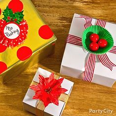 two present boxes with red poinsettis on them, one wrapped in paper and the other decorated with ribbon