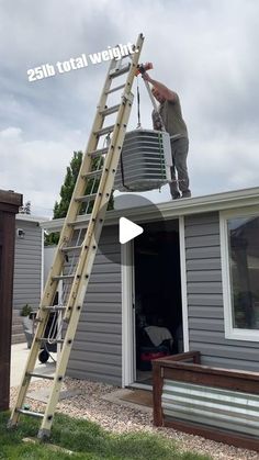 a man on a ladder painting the side of a house