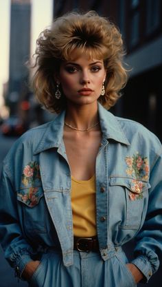 A model embodying the fashion of the 80s with an embroidered denim jacket, bold makeup, and voluminous hairstyle. Casual 80s Fashion, 80s Vs 90s Fashion, Women’s 80s Fashion, Retro Denim Outfits, 80 Costume Ideas For Women, 80's Costume Ideas, 80s Retro Outfit Ideas, Classic 80s Fashion