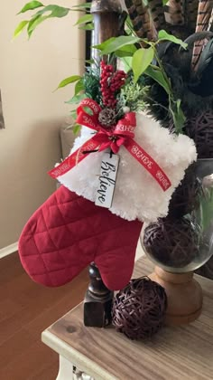 a christmas stocking is sitting on top of a table next to a potted plant