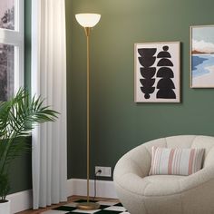 a living room with green walls and two pictures hanging on the wall next to a white chair