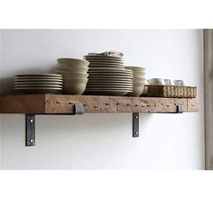 some plates and bowls are sitting on a shelf