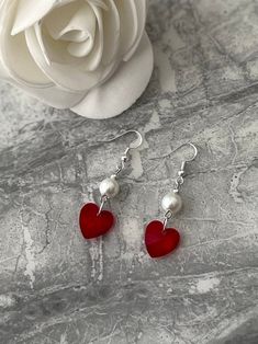 Red heart Pearl drop earrings. Free key chain with every order. Add a touch of elegance to your wardrobe with these timeless earrings. Handmade with love to elevate any look or outfit.  Sterling silver ear hooks with a red glass heart and faux Pearl drop design. The hearts are 14mm long, 14mm wide and 8mm thick. The Pearl is 8mm in size.    Free shipping to UK buyers. Dispatched within 1-3 days but I aim for next day postage.  Presented on a gift card and wrapped beautifully in luxury tissue paper and a blush pink organza bag to make these the perfect gift for loved ones.  If you aren't completely in LOVE with your purchase, please let me know and you'll receive a stress free refund. Customer satisfaction Is my main priority.  These are perfect for any occasion. Thank you for viewing and s Trendy Heart Charm Earrings As Gift, Trendy Double Heart Earrings As Gift, Trendy Heart Drop Earrings As Gift, Elegant Handmade Heart Earrings For Valentine's Day, Elegant Heart Detail Earrings For Gift, Elegant Earrings With Heart Detail, Elegant Heart Earrings With Heart Beads For Gifts, Elegant Heart Earrings With Heart Beads As A Gift, Elegant Heart Beads Earrings For Gift