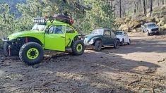 an off - road vehicle is parked on the side of a dirt road in front of other cars