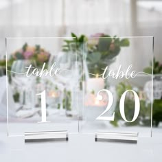 two clear acrylic table numbers sitting on top of a table