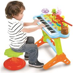 a little boy playing with a toy piano