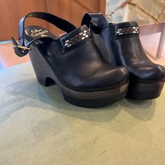 Stylish Calleen Cordero Studded Jeweled Leather Clogs; Black; Size 7; New Black Leather Clogs With Buckle Closure, Black Casual Clogs With Heel Strap, Chic Black Clogs With Heel Strap, Black Clogs With Heel Strap And Block Heel, Black Clogs With Heel Strap And Round Toe, Black Block Heel Clogs With Heel Strap, Black Mules With Wooden Heel And Ankle Strap, Chic Black Clogs With Leather Sole, Black Clogs With Ankle Strap And Leather Sole