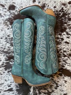 Embrace your inner Western-inspired fashionista with these gorgeous boots! They'll bring a luscious pop of deep teal into your wardrobe. They're sure to turn heads wherever you go. The intricate Western embroidery adorning the shaft adds a touch of traditional charm to the modern, eye-catching color. The classic cowboy boot silhouette, featuring a pointed toe and stacked heel, are the finishing touches. These amazing must-have boots are perfect for everything from dancing the night away to strutting down city streets. Womens Cowboy Boots Teal, Turquoise Cowgirl Boots With Black Dress, Womens Cowgirl Boots Summer, Luxury Blue Cowboy Boots For Fall, Western Boots Size 5, Western Boots Cavender's, Square Toe Boots Cowgirl Cavender's, Kentucky Western Boots, Womens Cowgirl Boots Concert