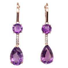 Stunning cocktail dangling amethyst earrings. High brilliance, lively purple tone, transparent clean, round faceted & pear faceted, natural 13.70 carats amethyst mounted with bead prong on high profile open basket, accented with a round brilliant diamond. Handcrafted dangling design set in 14 karats rose gold. Amethyst: 13.70 carats, high brilliance, lively purple tone, transparent clean Diamond: 0.15 carat round brilliant cut Color: G-H Clarity: SI1-SI2 Dimensions: H50mm x W10mm x D10mm (approx Amethyst Jewelry Necklace, Ruby Diamond Necklace, Ruby Diamond Pendant, Pink Diamond Earrings, Sapphire Diamond Necklace, Purple Tone, Cocktail Earrings, Fancy Yellow Diamond, Diamond Bangles Bracelet