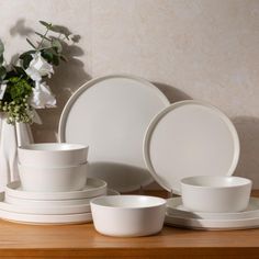 white dishes and cups are arranged on a wooden table