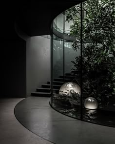 a circular room with stairs and plants in it