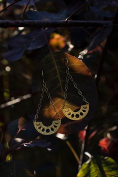 These handcrafted phases of the moon earrings have been inspired into creation by my love for and connection with the moon and her cyclical phases.  Solid raw brass arcs with the phases of the  moon cut out in them dangle from textured solid sterling silver chains and ear hooks.  I can make these earrings with either a regular ear hook or 16g hand hammered hoop ring that works well for stretched ears. See last pictures for stretched ear hoops and examples of the earrings with the stretched hoop Unique Sun And Moon Design Dangle Jewelry, Unique Sun And Moon Design Dangle Earrings, Unique Sun And Moon Dangle Earrings, Unique Dangle Earrings With Sun And Moon Design, Unique Moon Phase Metal Earrings, Unique Metal Moon Phase Earrings, Mystical Gold Moon Phase Earrings, Unique Sun And Moon Design Drop Earrings, Unique Sun And Moon Design Earrings As Gift