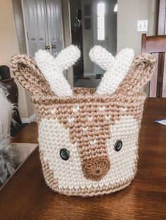 a crocheted deer basket sitting on top of a wooden table