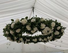 white flowers hanging from the ceiling in a tent