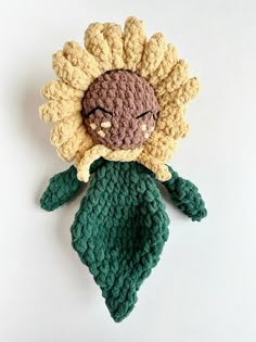 a crocheted doll with a flower on it's head is laying down