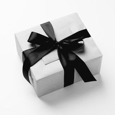 a white box with a black ribbon on it