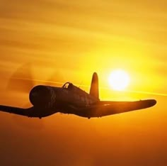 an airplane flying in the sky at sunset