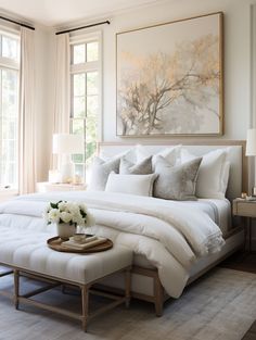 a bed with white linens and pillows in a bedroom next to a large window