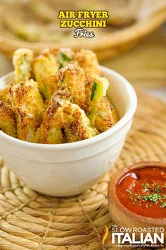 a bowl filled with fried zucchini on top of a table