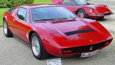 two red sports cars parked next to each other