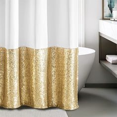 a bath tub sitting next to a white sink under a window covered in gold sequins