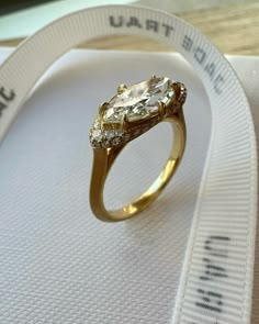 a close up of a ring on top of a white cloth with a measuring tape