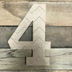 the number four is made out of cardboard and sits on top of wood planks