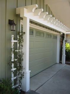 a garage with a white trellis on the side