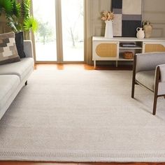 a living room filled with furniture and a white rug