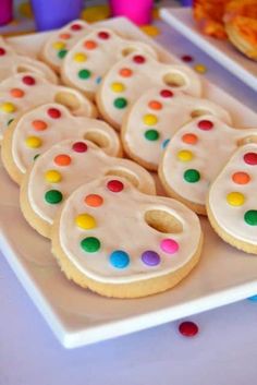 there are many decorated cookies on the plate and one is white with multicolored dots