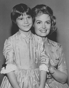 two women are posing for the camera in black and white, one is holding her arm around the other woman's shoulder