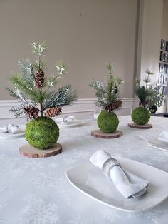 the table is set with white plates and place settings