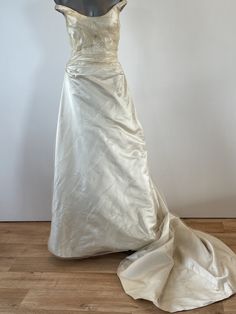 A unique opportunity to own a beautiful Vintage Caroline Holmes Couture Gown at just 10% of it's original value from our Knightsbridge Salon.  The Gown is handmade from the finest silks, silk lined to create that extra special feeling of elegance to it's wearer. Description: Petite ivory silk duchess satin princess line gown with silk tulle and crystal overlay. Draped fitted bodice flowing into A-line skirt into train. Side concealed zipper fastening. Off the shoulder straps UK size  10 (petite) Fitted Bodice Ball Gown Wedding Dress With Sweep Train, Champagne Gown With Sweep Train For Debutante Ball, Wedding Floor-length Gown With Boned Bodice, Silk Ball Gown With Fitted Bodice, White Ball Gown With Lined Bodice, Silk Wedding Gown With Pleated Bodice, Cream Satin Floor-length Gown, Silk Cream Evening Dress With Fitted Bodice, Satin Gown With Detachable Train And Fitted Bodice