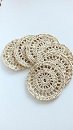 four crocheted coasters sitting on top of a table