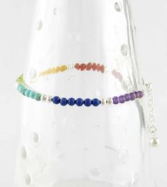 Material: 100% Sterling silver, with amethyst, carnelian, lab ruby, lapis lazuli, peridot, reconstructed turquoise, and yellow agate Length: 7 inches + 1 inch extender (18 + 3 cm) Inside measurements when fully extended: About 2-1/2 inches (6 cm) Item number: wh099 This colorful bracelet is strung with tiny round beads in the colors of the spectrum or rainbow. The beads are about 1/8 inch in diameter and are made of amethyst, carnelian, lab ruby, lapis lazuli, peridot, reconstructed turquoise an Adjustable Rainbow Jewelry With Faceted Beads, Rainbow Gemstone Beads Healing Bracelet, Rainbow Gemstone Beads Bracelet, Adjustable Rainbow Gemstone Beads Bracelet, Rainbow Multi-stone Bracelet, Chakra Beads, Necklace Length Guide, Metal Clay Jewelry, Casting Jewelry