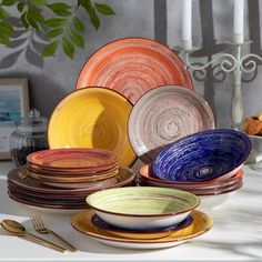 there are many different colored plates on the table