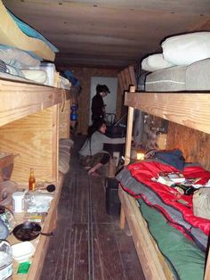 two people are sitting on bunk beds in a small room