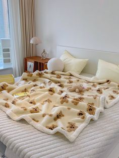 a bed with a teddy bear blanket on top of it