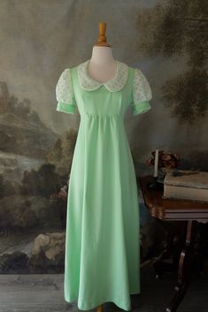 "Everyone will be green with envy when they see you in this lovely retro vintage 60s maxi dress! It is perfect for any Jane Austen fan with its Regency era silhouette. The color is a beautiful green sorbet. Darling eyelet lace is featured on the puff sleeves. It has an empire waist, with a zipper in the back and ties. It is in pristine condition.  Brand: Union Made  No noticeable flaws Size: Approximately modern Small Measurements:  19\" underarm to underarm  16\" empire waist 10\" sleeve length  6\" arm opening 54.5\" length *All vintage items are FINAL SALE. Please email with any questions before purchasing. We are happy to help with any inquires! *Please note that though we look over each vintage and antique item extensively and note flaws in descriptions, these are still aged items of Fitted Green Maxi Dress With Empire Waist, Fitted Green Maxi Dress For Daywear, Green Retro Vintage Dress, Green Retro Vintage Dress With Short Sleeves, Fitted Green Vintage Dress, Retro Daywear Maxi Dress, Retro Maxi Dress For Daywear, Retro Floor-length Dresses For Vintage Fashion, Retro Floor-length Vintage Fashion Dress