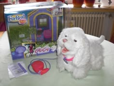 a white dog sitting on top of a table next to a package of play dough