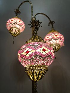 three pink and white lamps on a black pole