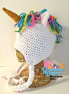 a crocheted unicorn hat with multicolored manes on it's head