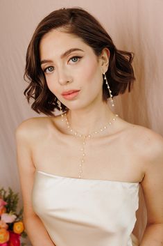 Add a touch of graceful elegance to your bridal look with the Whispering Pearl Drop Earrings! These stunning dangle earrings feature freshwater pearls delicately hanging from a fine gold chain, creating a perfect balance of timeless beauty and modern sophistication. Why do we love them? They’re the perfect blend of chic and classic beauty, making them a must-have for your special day! EARRING FEATURES Material: Brass, Freshwater Pearls Dimensions/Size: 3.2" drop Finish: Polished 14k Gold Plating Feminine Pearl Earrings With Pearl Chain, Elegant Teardrop Pearl Necklace With Delicate Chain, Elegant Pearl Teardrop Necklace With Delicate Chain, Dainty Pearl Charm Earrings For Parties, Elegant Jewelry With Dangling Beads, Elegant Pearl Charm Chandelier Dangle Earrings, Elegant Drop Pearl Earrings With Dangling Beads, Elegant Pearl Charm Chandelier Earrings, Elegant Pearl Chandelier Earrings With Dangling Beads